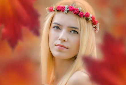 HD desktop wallpaper of a blonde woman model with a floral wreath on her head, softly blurred autumn leaves framing her serene face.