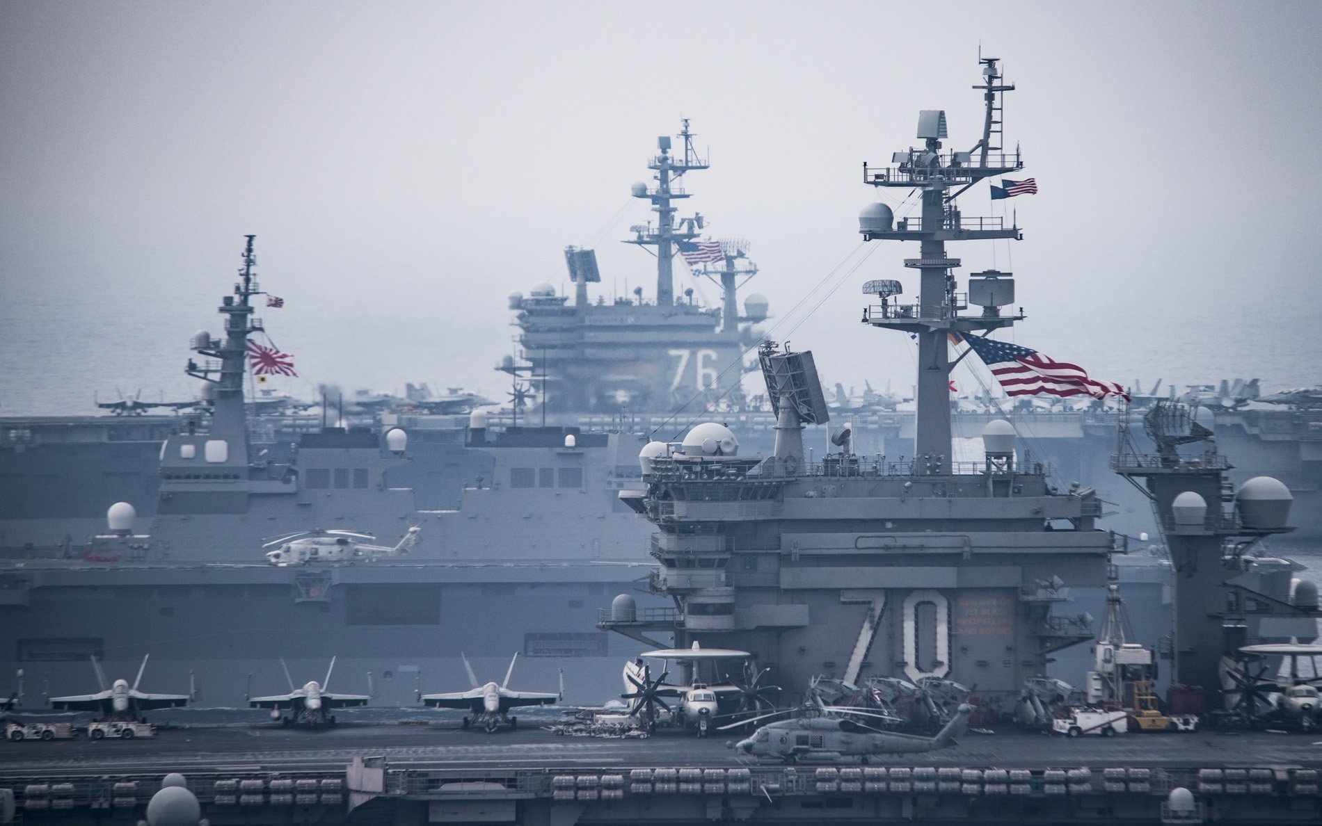 HD desktop wallpaper: warships and aircraft carriers USS Ronald Reagan (CVN-76) and USS Carl Vinson (CVN-70) steaming in formation under an overcast gray sky.