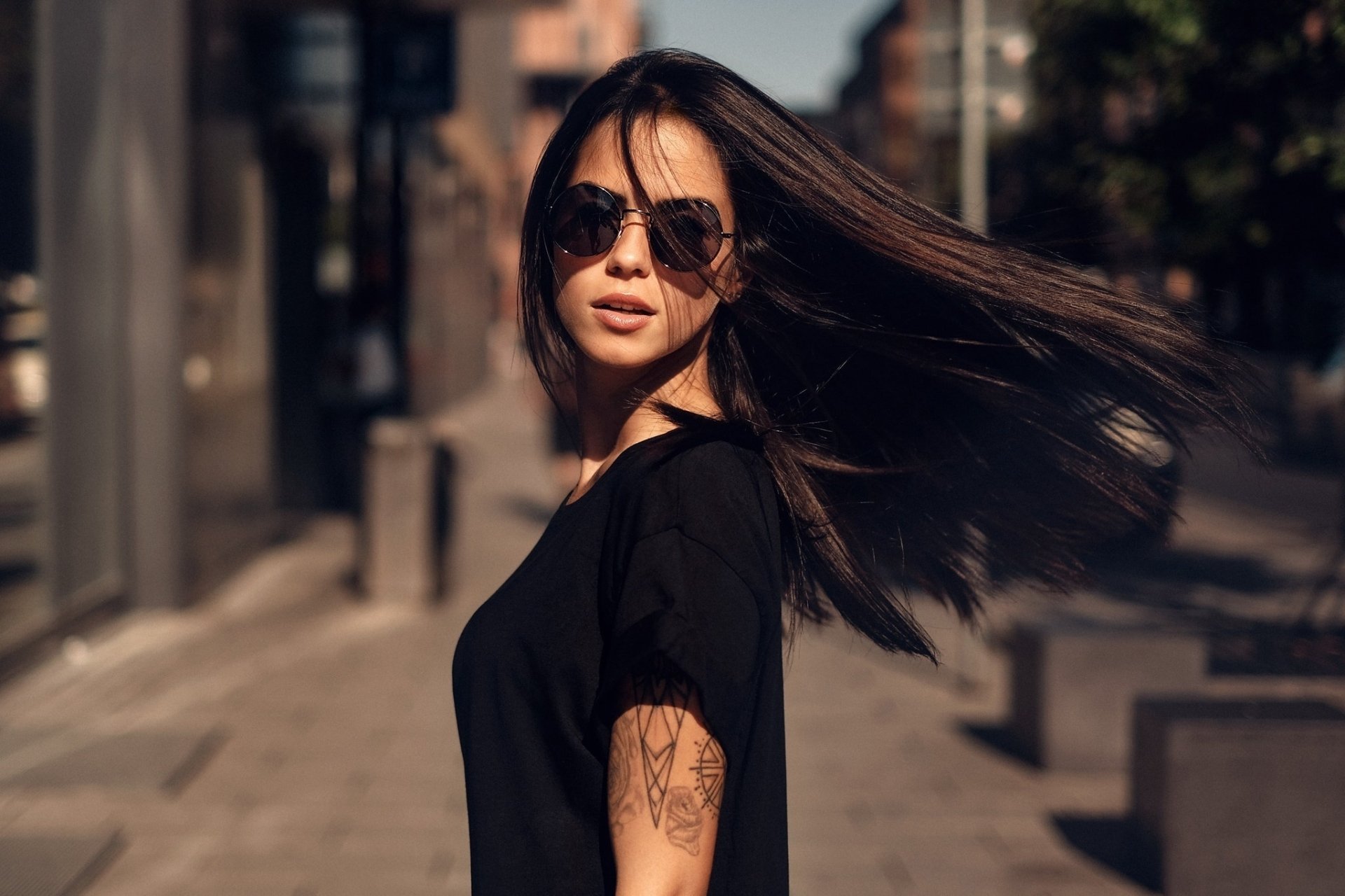 HD desktop wallpaper featuring brunette model Marlen Valderrama Alvaréz wearing sunglasses with a depth of field effect in an urban setting.