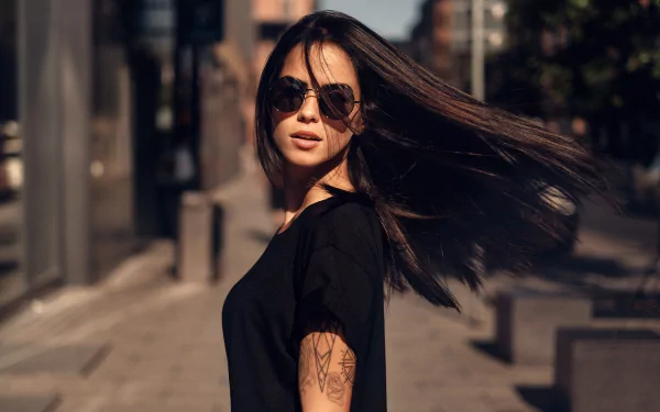 HD desktop wallpaper featuring brunette model Marlen Valderrama Alvaréz wearing sunglasses with a depth of field effect in an urban setting.