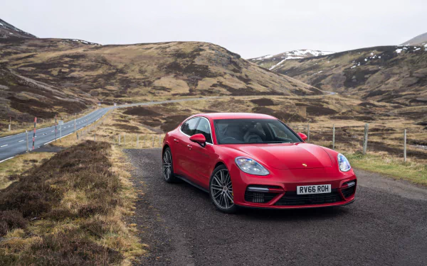 Red Porsche Panamera Turbo parked on a rural road with rugged hills in the background, captured in 4K Ultra HD for a PC desktop wallpaper.