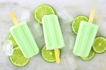 Four lime-flavored ice cream popsicles with ice cubes and lime slices, captured in vibrant 4K Ultra HD detail, creating a refreshing and colorful food-themed desktop wallpaper.