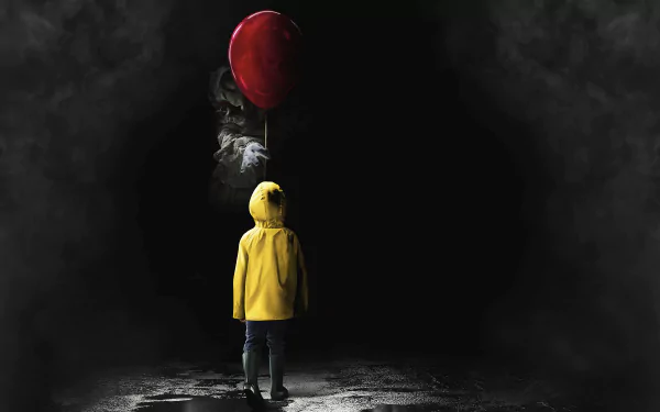 A HD desktop wallpaper from the 2017 movie It, featuring a child in a yellow raincoat standing in front of a dark figure holding a red balloon.