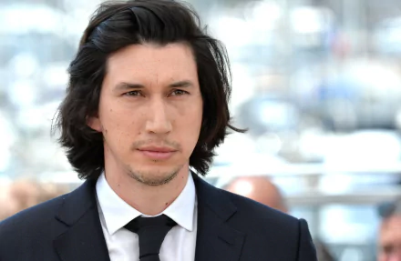 HD wallpaper featuring a man in a black suit and tie with medium-length dark hair, suitable as a desktop background.
