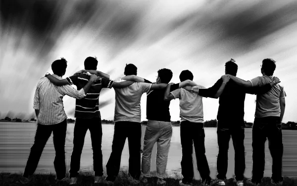 HD desktop wallpaper featuring a group of friends standing side by side with arms around each other, in black and white against a dramatic sky.