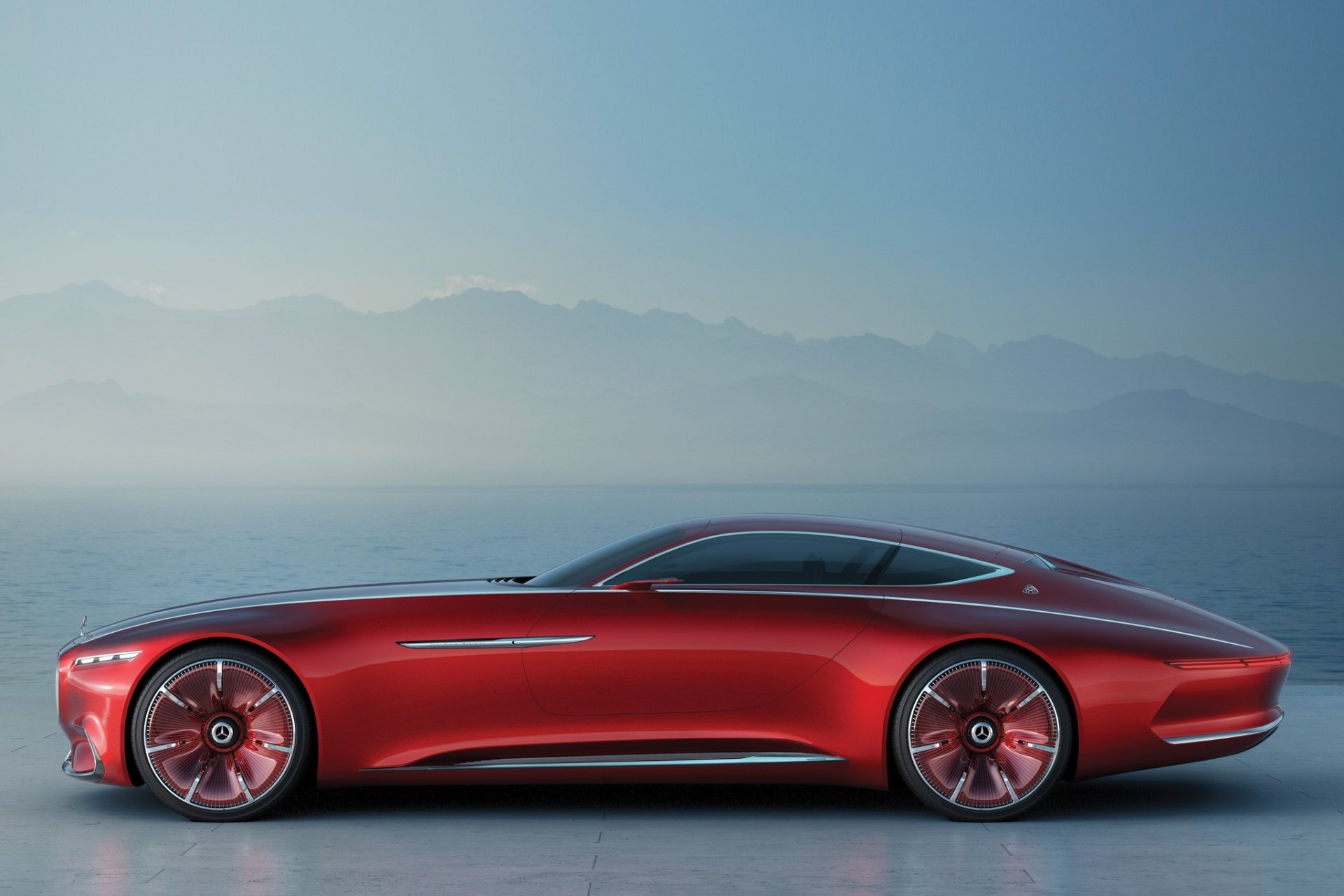 Sleek red Mercedes-Maybach 6 grand tourer concept car showcased against a misty mountain backdrop, captured in high-definition for a desktop wallpaper.