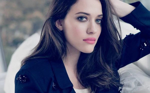 HD desktop wallpaper featuring a close-up portrait of celebrity Kat Dennings with long dark hair and a contemplative expression.