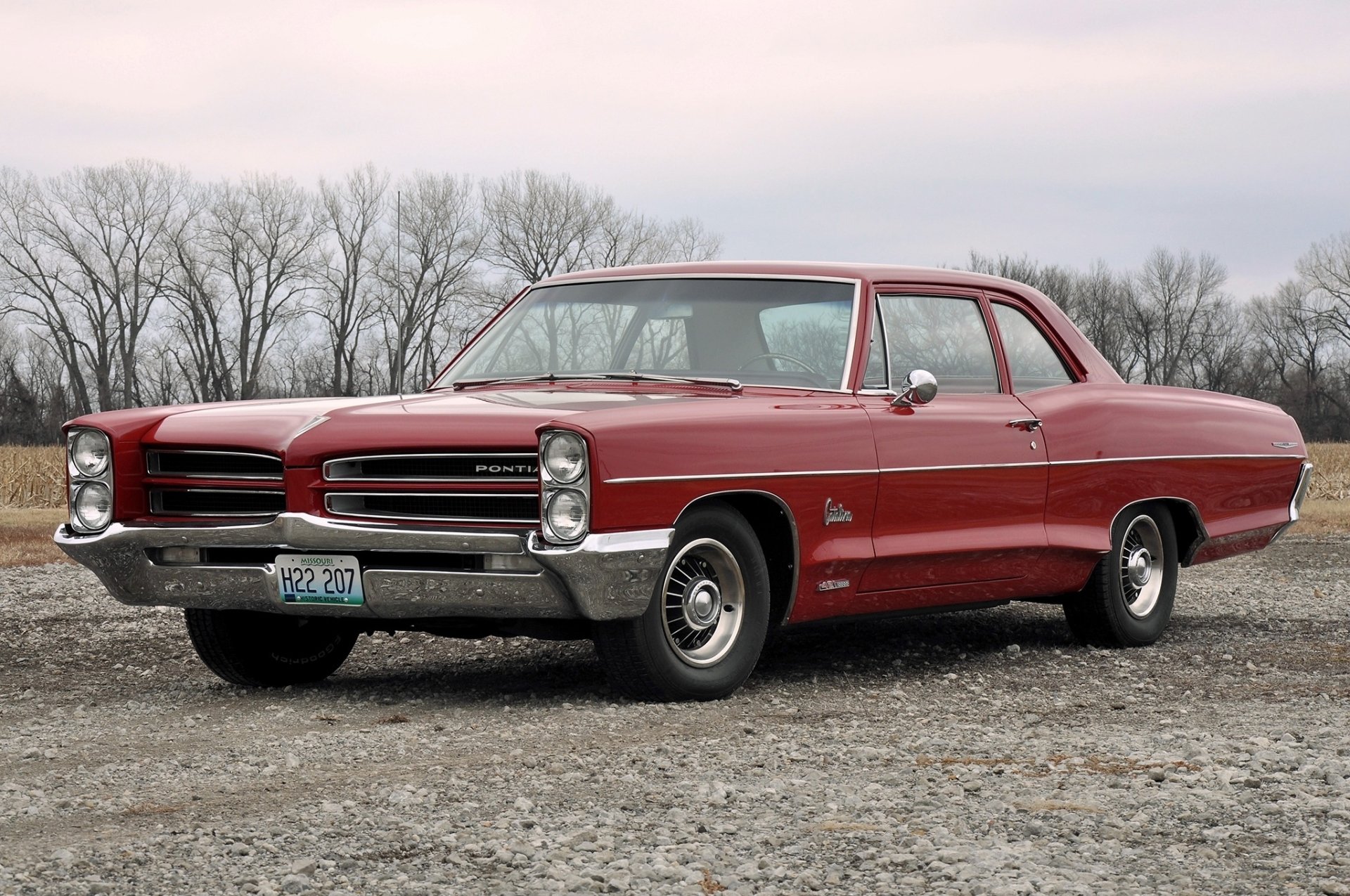 Red Pontiac Catalina coupe on gravel under a pale sky — classic Pontiac vehicle rendered as an HD PC desktop wallpaper/background.