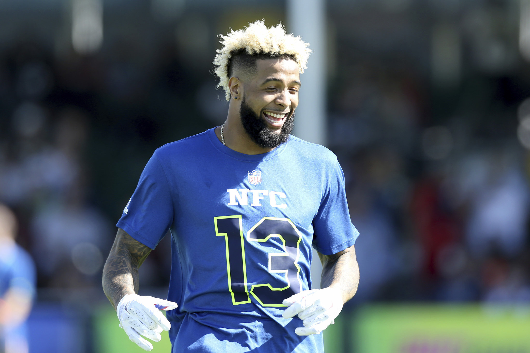 HD wallpaper featuring New York Giants player Odell Beckham Jr. in a blue NFC #13 jersey, smiling on the field.