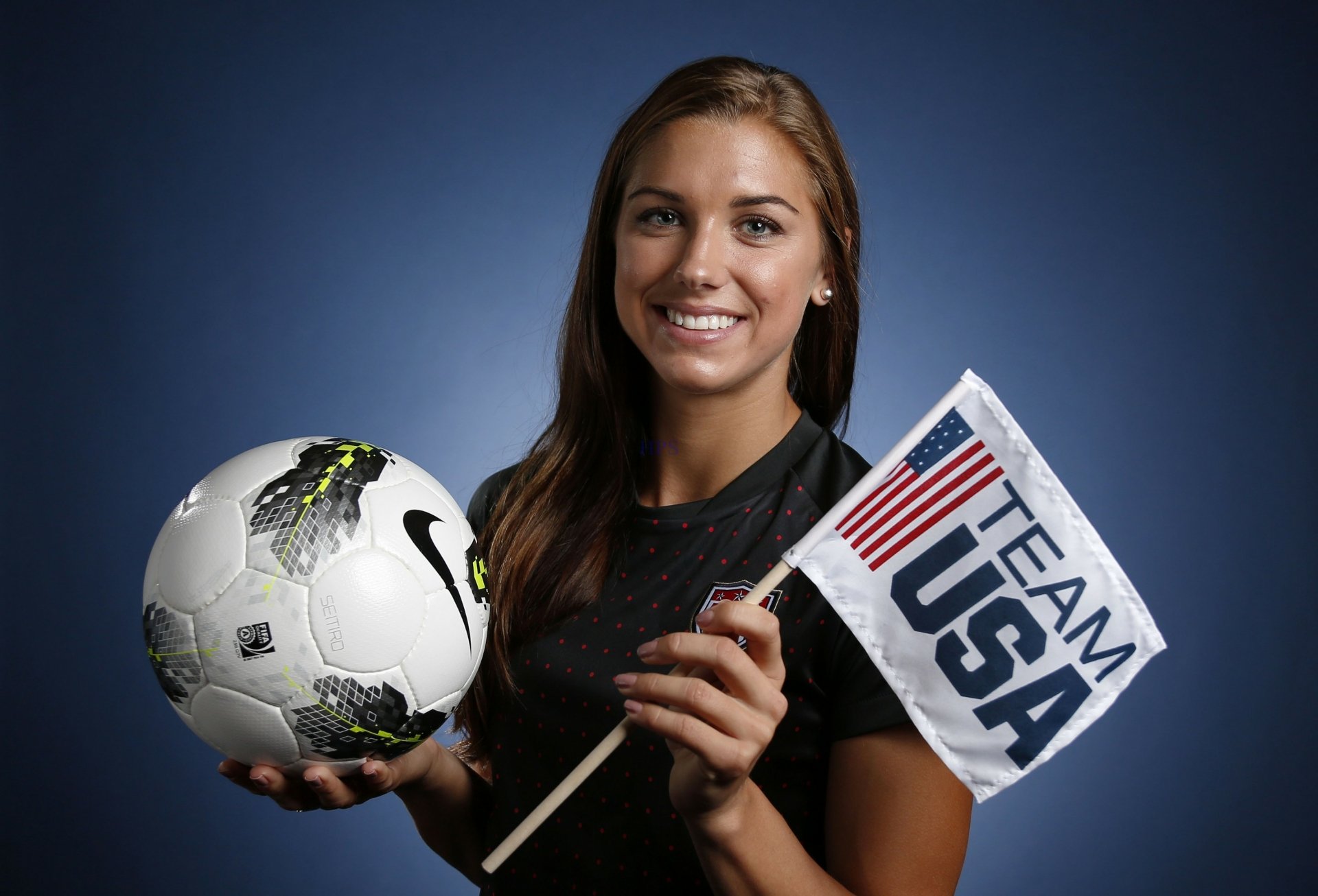 HD desktop wallpaper featuring a person holding a soccer ball and a Team USA flag, exuding confidence and pride.