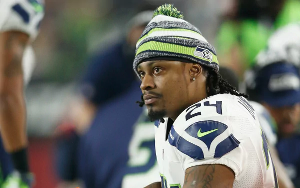 HD wallpaper of a Seattle Seahawks player on the field, capturing the intensity of the game.