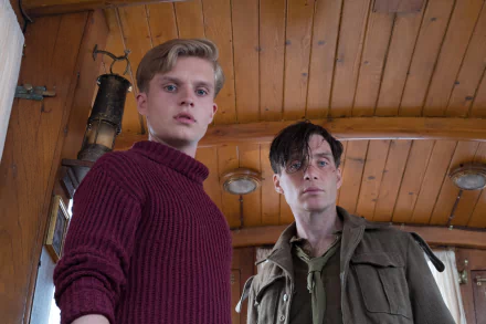 HD desktop wallpaper featuring Tom Glynn-Carney and Cillian Murphy in a scene from the movie Dunkirk. The actors are indoors with a wooden ceiling background.