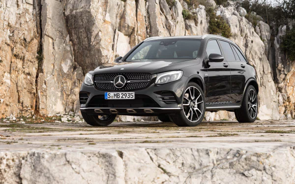 Black Mercedes-Benz GLC-Class SUV parked on rocky terrain, showcased in a 4K Ultra HD desktop wallpaper highlighting its sleek design and rugged presence.