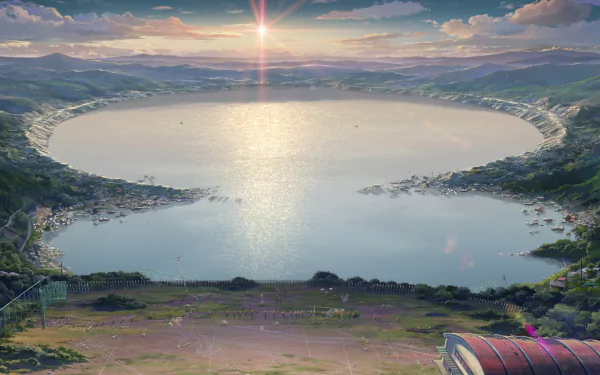 Anime-style HD desktop wallpaper featuring a serene crater lake under a vibrant sky with clouds, surrounded by mountains, and a school in the foreground. Inspired by Your Name.