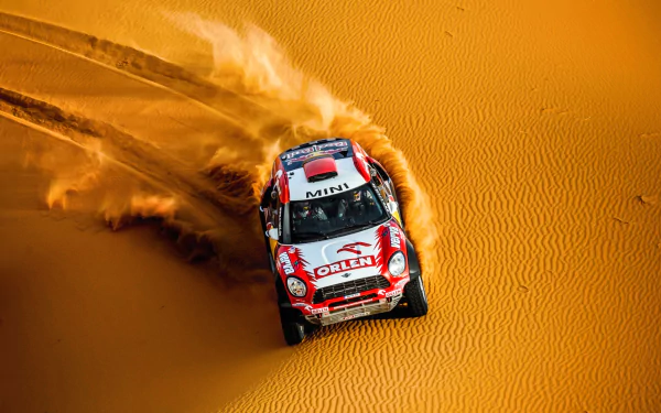 HD desktop wallpaper featuring a rally car racing through sand dunes, capturing the excitement and movement of a desert rally sport.