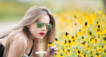 A blonde woman in sunglasses and red lipstick, photographed with depth of field, poses among yellow flowers. This HD image serves as a stunning desktop wallpaper and background.