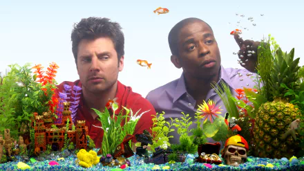 2K Quad HD PC desktop wallpaper/background: two characters from TV show Psych peer into a colorful aquarium filled with tropical plants, goldfish, a pineapple and a skull ornament.