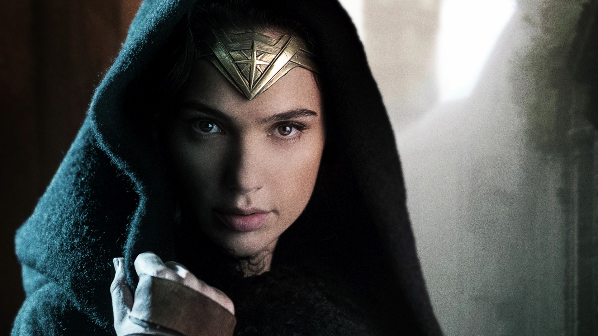 HD desktop wallpaper featuring Gal Gadot as Diana of Themyscira, also known as Wonder Woman, from the movie. She is hooded and gazing intently, symbolizing strength and determination.