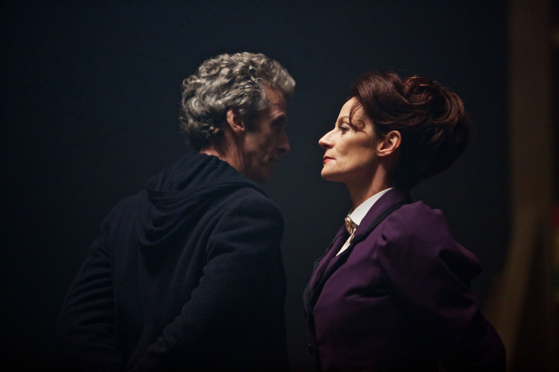 Peter Capaldi as the 12th Doctor in Doctor Who (2005) sharing an intense moment with a woman, captured in a 4K Ultra HD TV show wallpaper background.