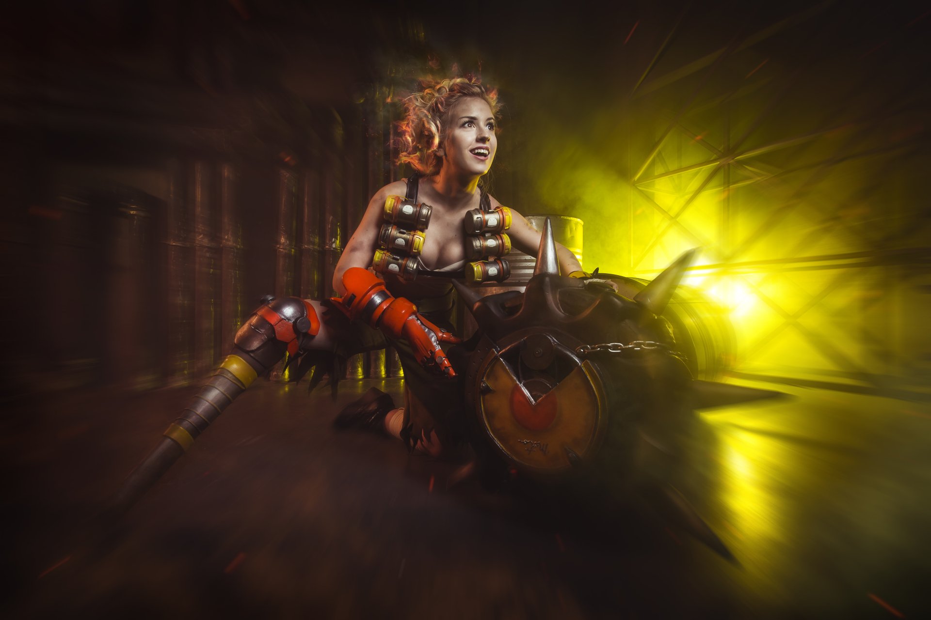 4K Ultra HD desktop wallpaper: female cosplayer as Junkrat from Overwatch, crouched with a spiked tire bomb and a glowing yellow-green explosion backdrop.