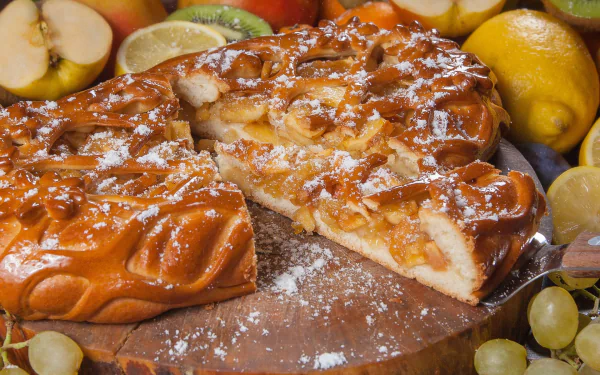 Close-up HD desktop wallpaper of a glossy apple pastry pie surrounded by fresh lemons and apple slices, highlighting vibrant colors and detailed textures.