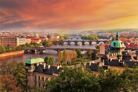 A stunning 4K Ultra HD view of Prague, Czech Republic, showcasing the river with historic bridges and the cityscape under a vibrant sunset sky.