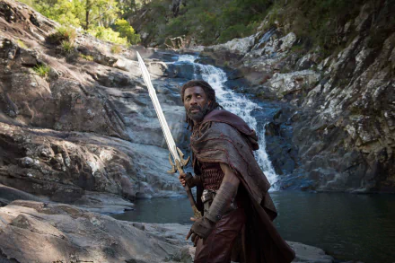 HD desktop wallpaper featuring Idris Elba as Heimdall in Marvel's Thor: Ragnarok, in front of a scenic waterfall background.