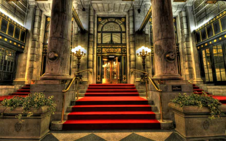 A grand hotel entrance featuring ornate columns and a striking red carpet leading to the double doors, beautifully captured in HDR for an impressive desktop wallpaper.