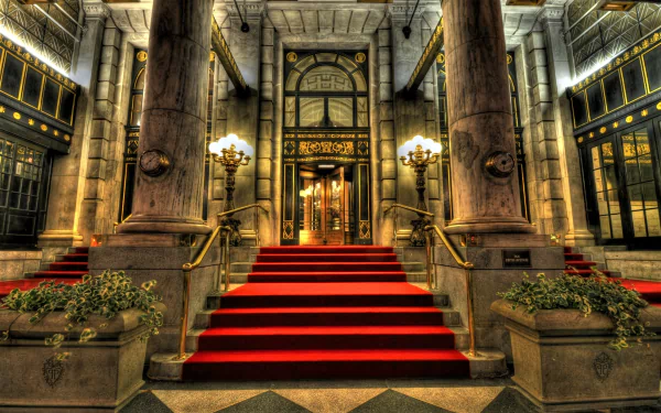 A grand hotel entrance featuring ornate columns and a striking red carpet leading to the double doors, beautifully captured in HDR for an impressive desktop wallpaper.