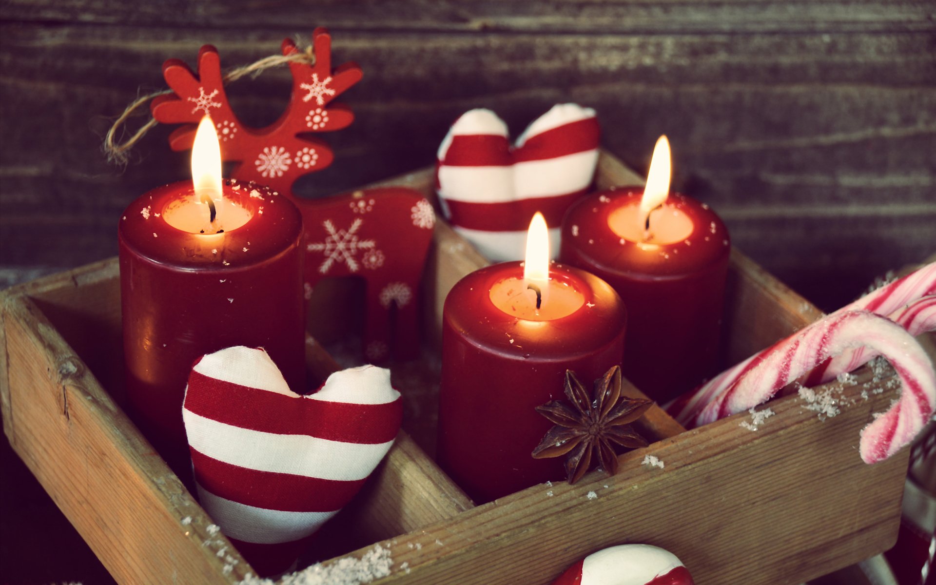 A cozy holiday scene with lit red candles, striped candy canes, and heart-shaped decorations, captured in an HD Christmas desktop wallpaper.