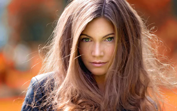 HD desktop wallpaper featuring a close-up of Sophie Breidenstein, a brunette model with green eyes and freckles, captured with a shallow depth of field.
