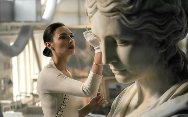 HD desktop wallpaper featuring Gal Gadot as Diana Prince/Wonder Woman from the movie Justice League, standing beside a detailed statue she is working on.