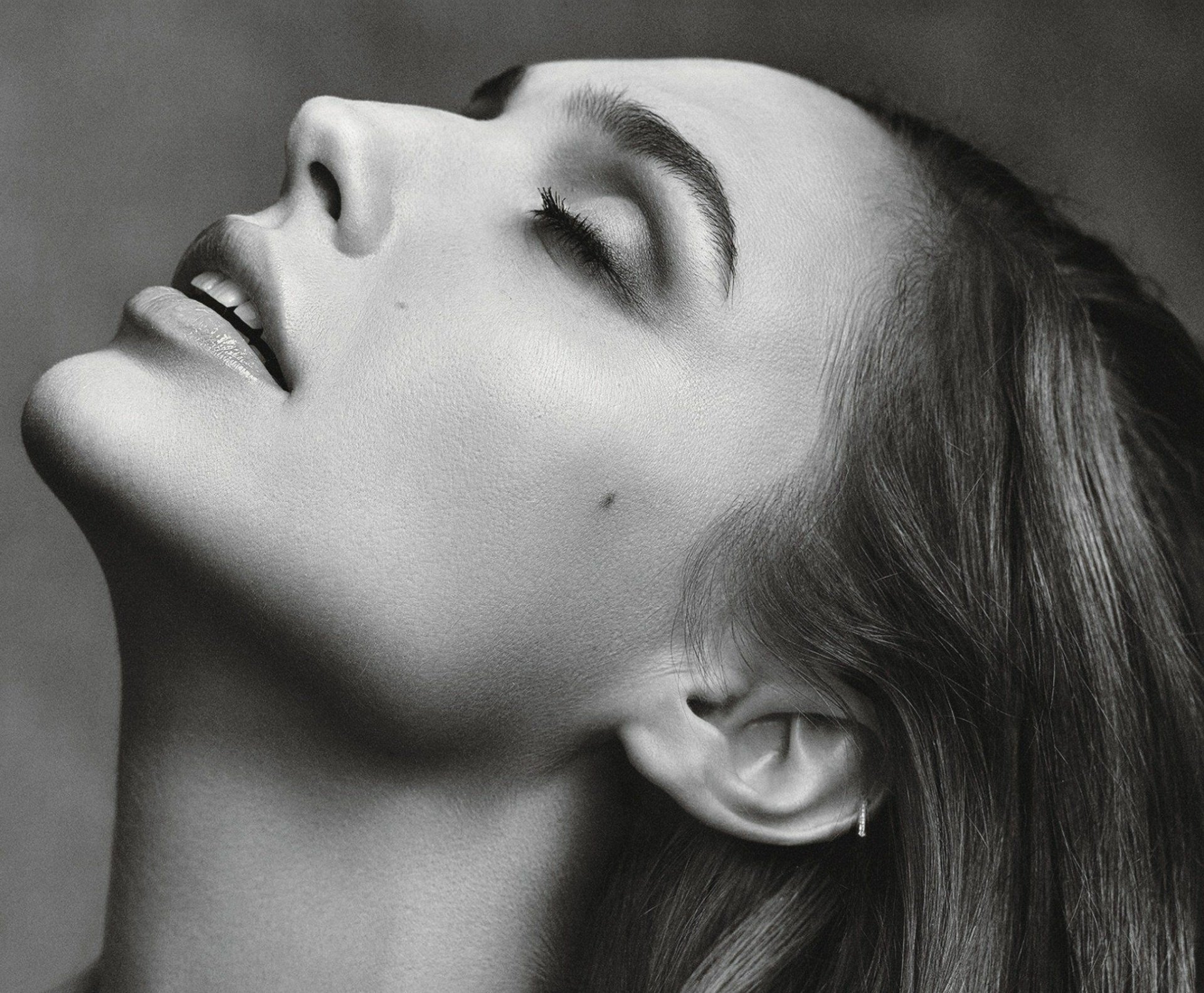 Black and white close-up portrait of an Israeli model and actress exuding a serene mood, serving as a high-definition PC desktop wallpaper and background.