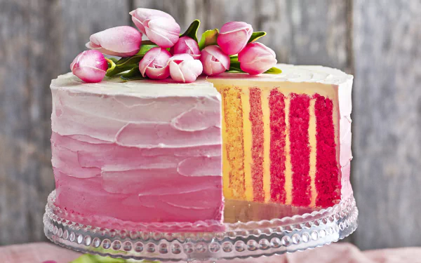 A layered cream pastry cake with pink and yellow stripes, decorated with pink tulip flowers, displayed as a HD PC desktop wallpaper and background.