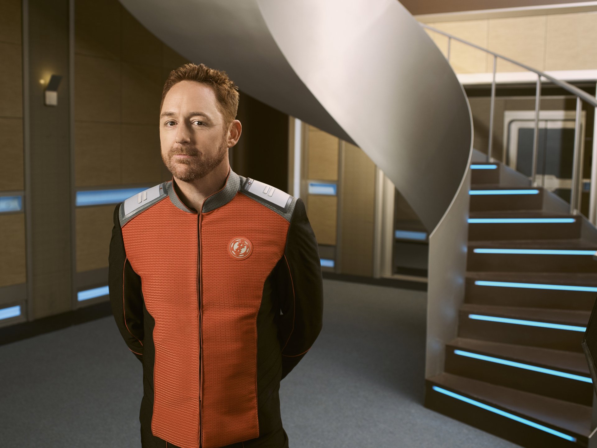 HD desktop wallpaper of a character from The Orville, standing in the corridor of a spaceship.