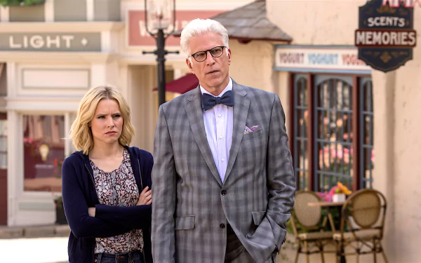 HD desktop wallpaper featuring two characters from The Good Place standing in front of quaint storefronts.