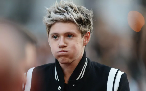 HD desktop wallpaper of a person with expressive eyes, wearing a varsity jacket, providing a thoughtful background.