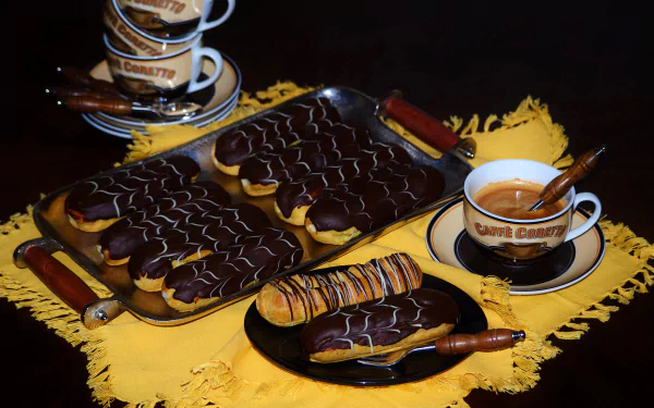 A still life 4K Ultra HD wallpaper featuring chocolate éclairs and a cup of coffee arranged on a yellow cloth, showcasing a rich dessert and pastry scene.
