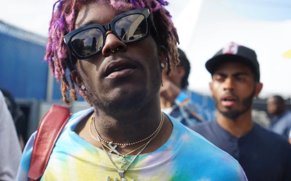 HD desktop wallpaper featuring a person with purple hair and sunglasses, tagged as Lil Uzi Vert, with a blurry background.