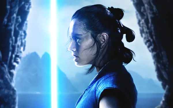 HD desktop wallpaper of Rey from Star Wars: The Last Jedi, portrayed by Daisy Ridley, holding a lit lightsaber, set against a dramatic backdrop of rocky cliffs and distant mountains.