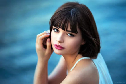 Close-up portrait of brunette model Marie Grippon with lipstick, looking over her shoulder against a blurred blue background, captured in HD for a desktop wallpaper.