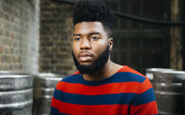 HD desktop wallpaper featuring an individual in a striped shirt with an urban backdrop.