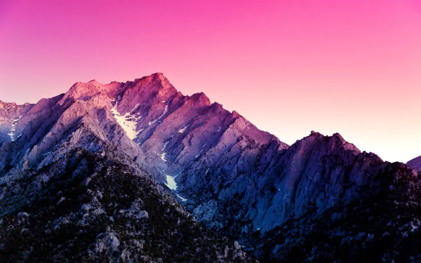 HD desktop wallpaper featuring rugged mountain cliffs against a vibrant pink sky, showcasing the beauty of nature.