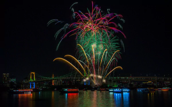 HD PC desktop wallpaper: night photography of Tokyo's Rainbow Bridge with colorful fireworks over Tokyo Bay, Japan, reflections shimmering on the water.