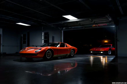 Orange Lamborghini Miura in a dim garage with glossy floor reflections, a second Miura in the background — HD PC desktop wallpaper of a classic car/vehicle.