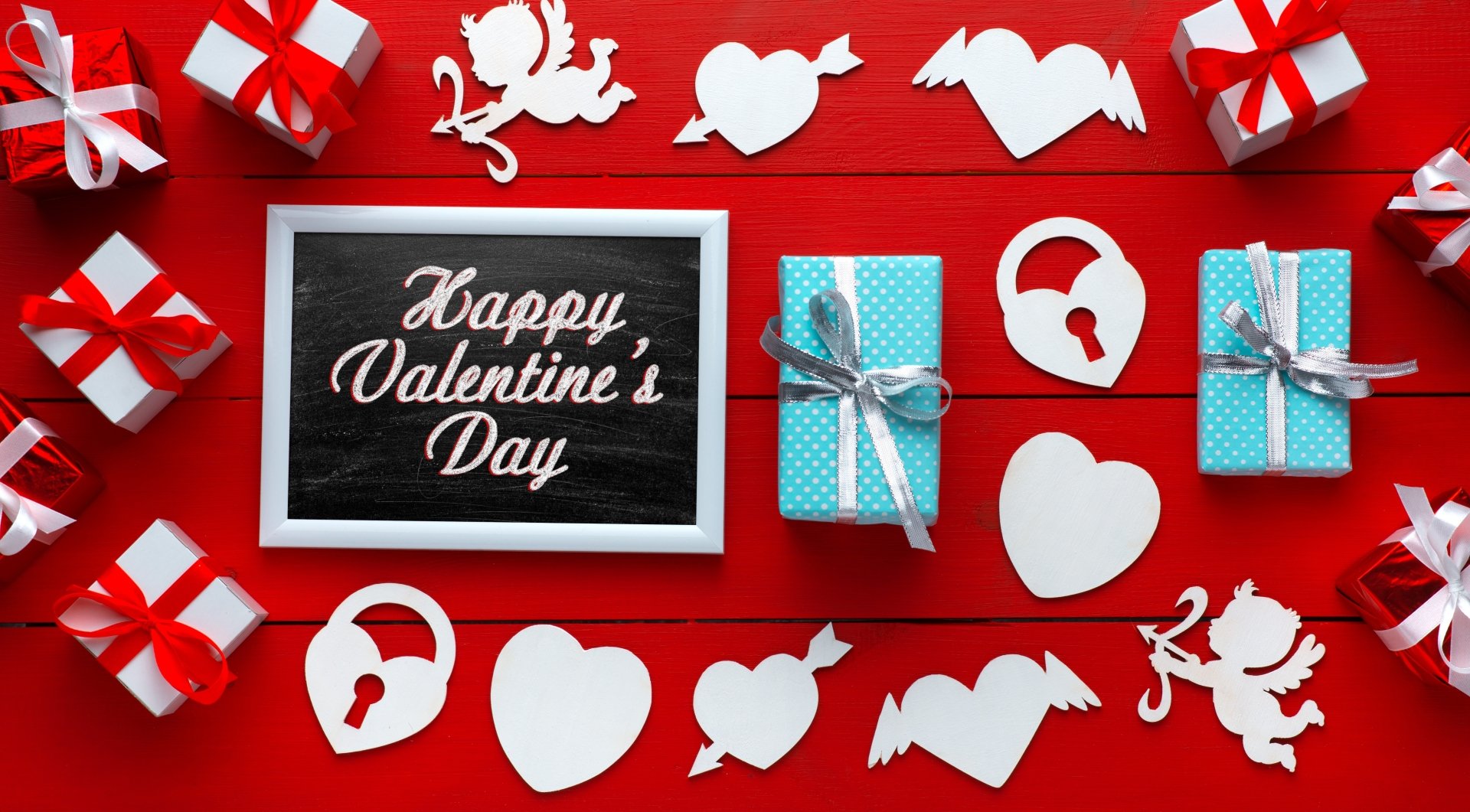 4K Ultra HD Valentine's Day desktop wallpaper featuring red and white gift boxes, heart and cupid cutouts, and a chalkboard reading Happy Valentine's Day.