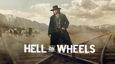2K Quad HD wallpaper for TV show Hell on Wheels: lone gunslinger in a black coat and hat stands on railroad tracks with workers and snowy mountains under a dramatic sky.