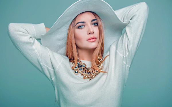 5K Ultra HD PC desktop wallpaper of a model woman wearing a wide-brim hat, bold lipstick and a layered statement necklace against a soft teal background.
