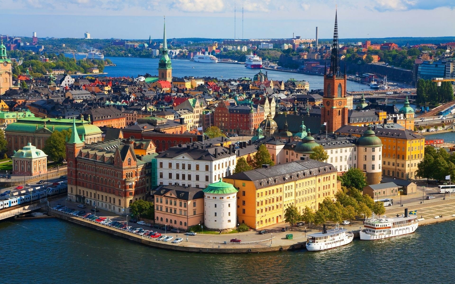 HD cityscape of Stockholm, Sweden, showcasing vibrant historic buildings along the waterfront under a clear blue sky.