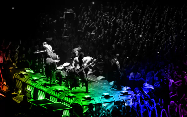 HD PC desktop wallpaper: colorful, rainbow-lit industrial metal concert scene with a Rammstein-inspired stage and packed crowd.